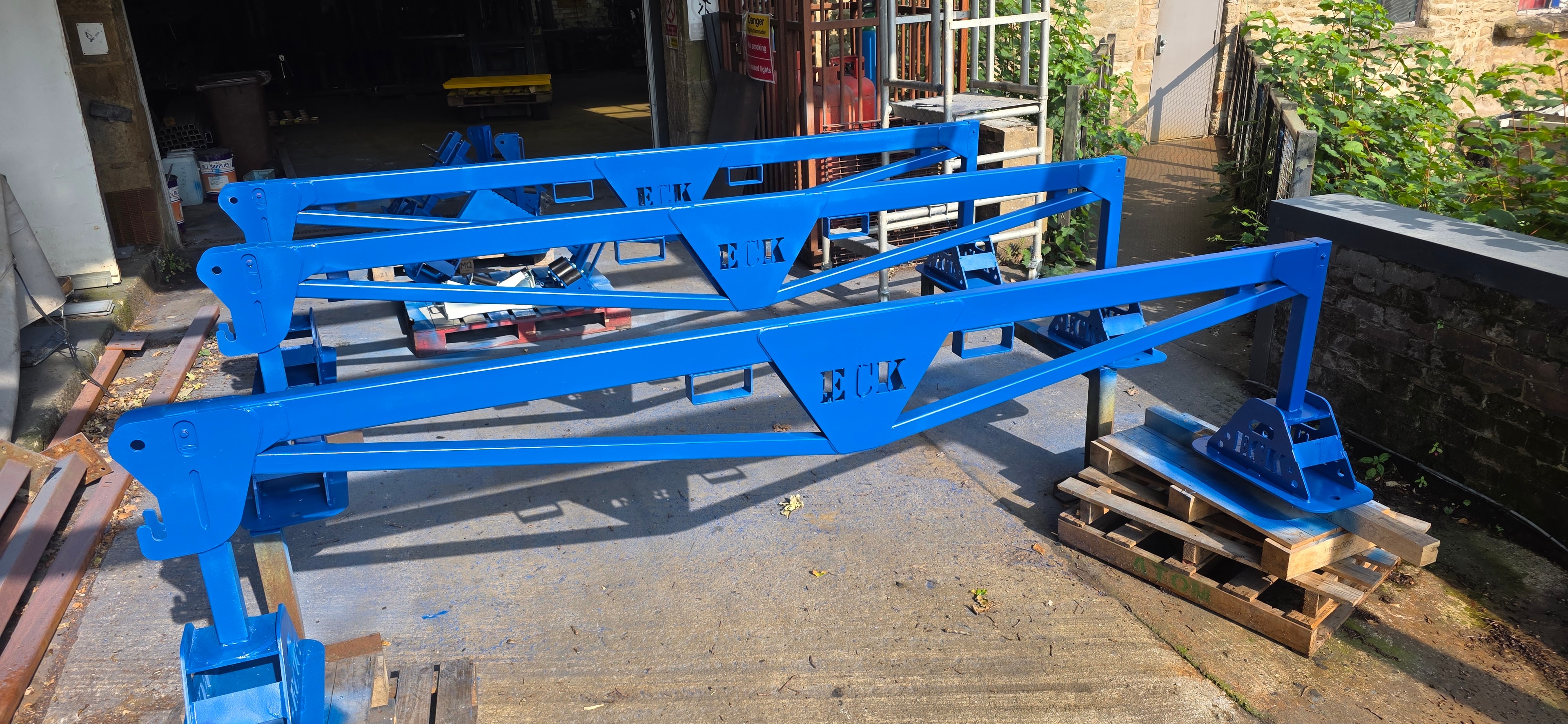 Blue painted steel boat frames outside workshop