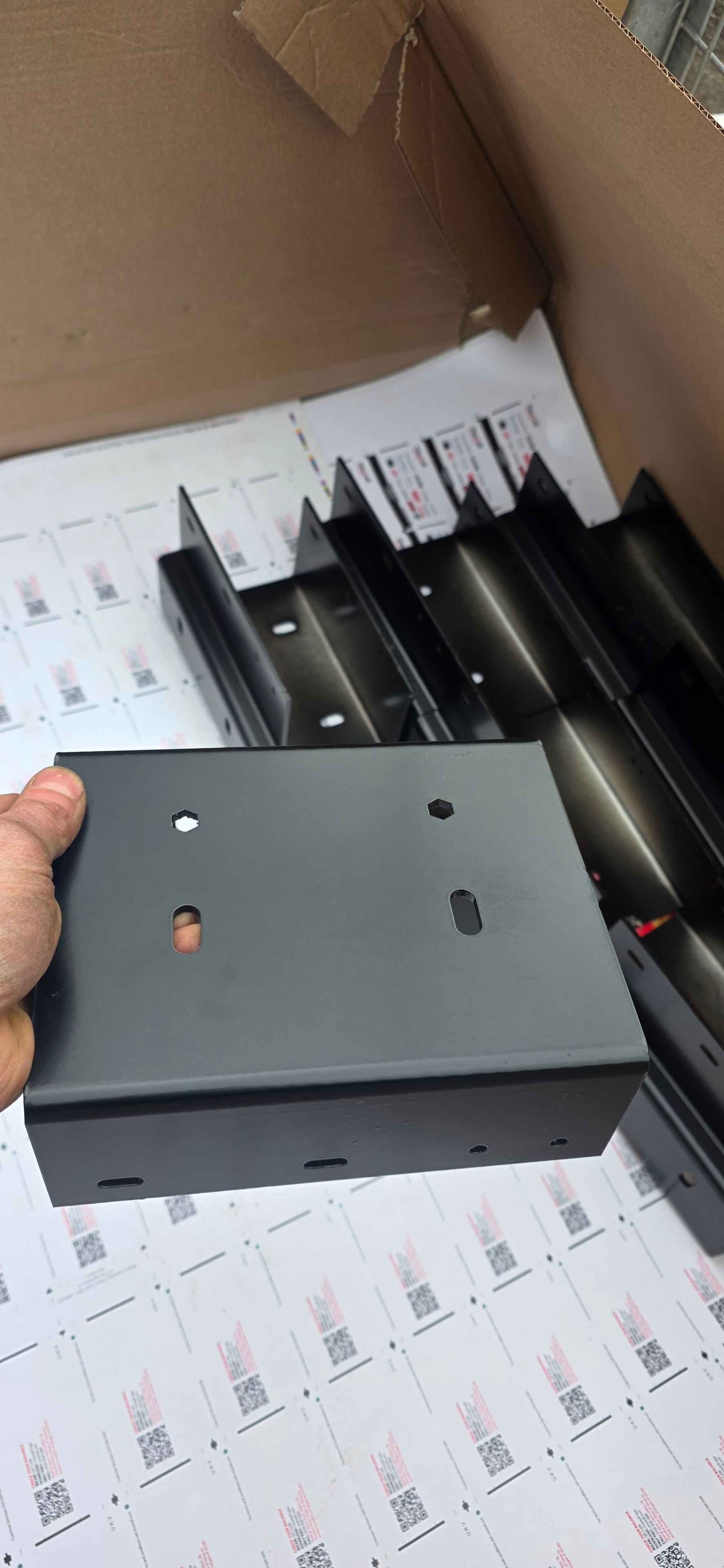 Fabricated steel enclosure box held up for inspection